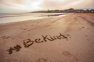 'Be Kind' written on the sand at the West Sands, St Andrews